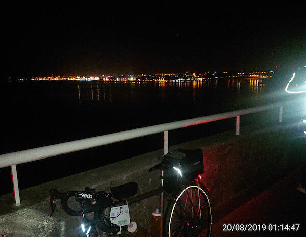 Lichter von Häusern in der Nacht mit Fahrrad im Vordergrund