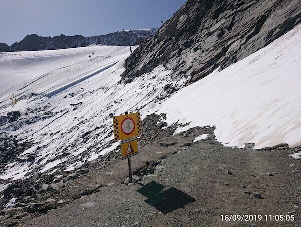 Schild weg gesperrt, dahinter Steiler Abhang mit Schnee bedeckt